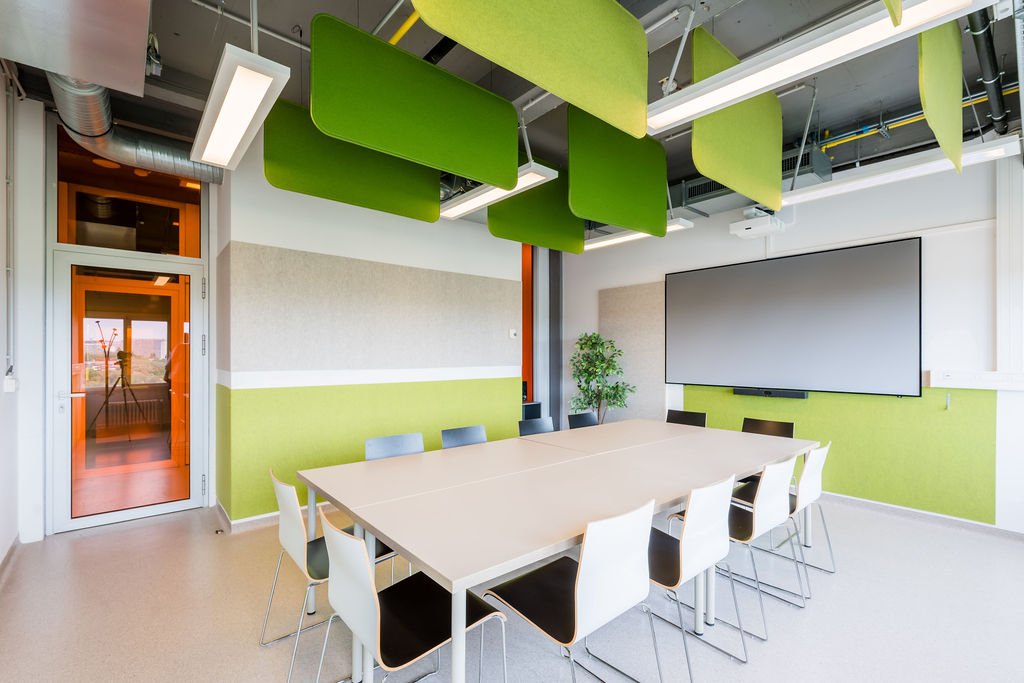 Salle de r&eacute;union du BLSI &agrave; Bruxelles pouvant accueillir jusqu&rsquo;&agrave; quatorze personnes autour d&rsquo;une grande table, &eacute;quip&eacute;e d&rsquo;un &eacute;cran de projection mural de 100 pouces